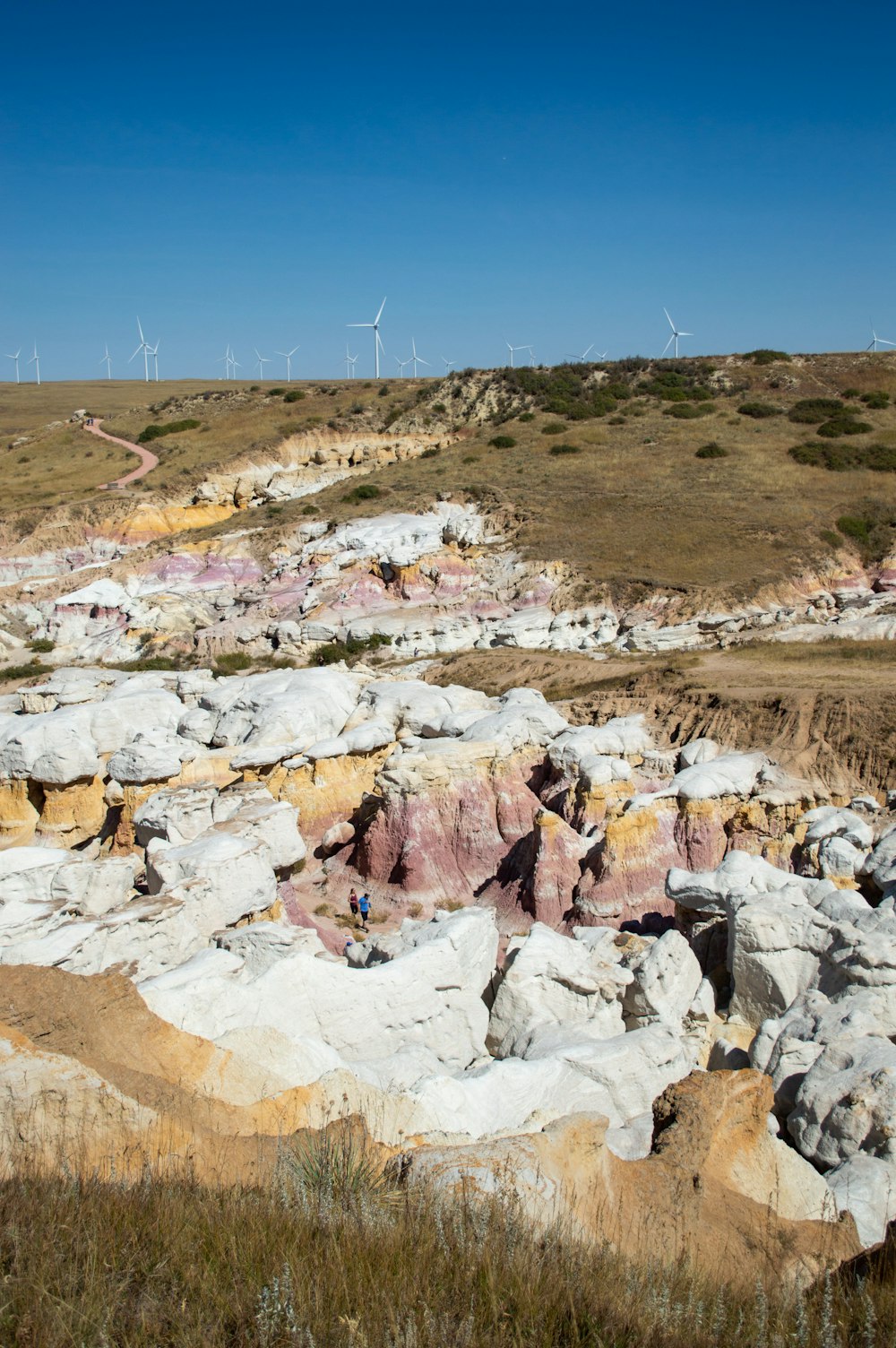 a view of a rocky landscape with wind mills in the background