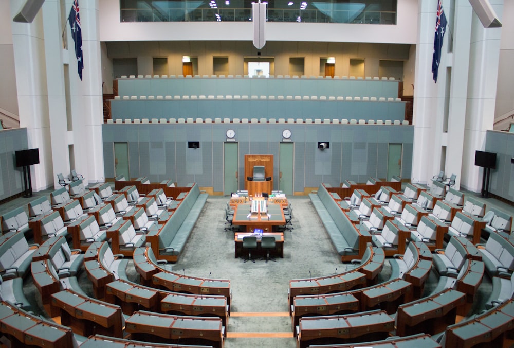 une grande salle avec des rangées de chaises et un podium