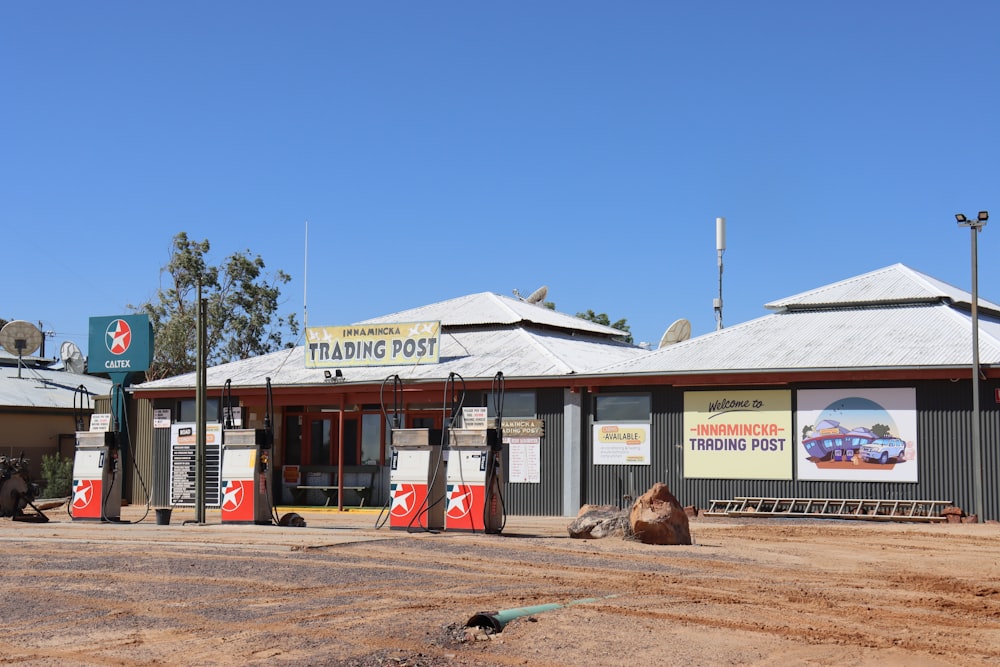 a dirt parking lot with a gas station in the background
