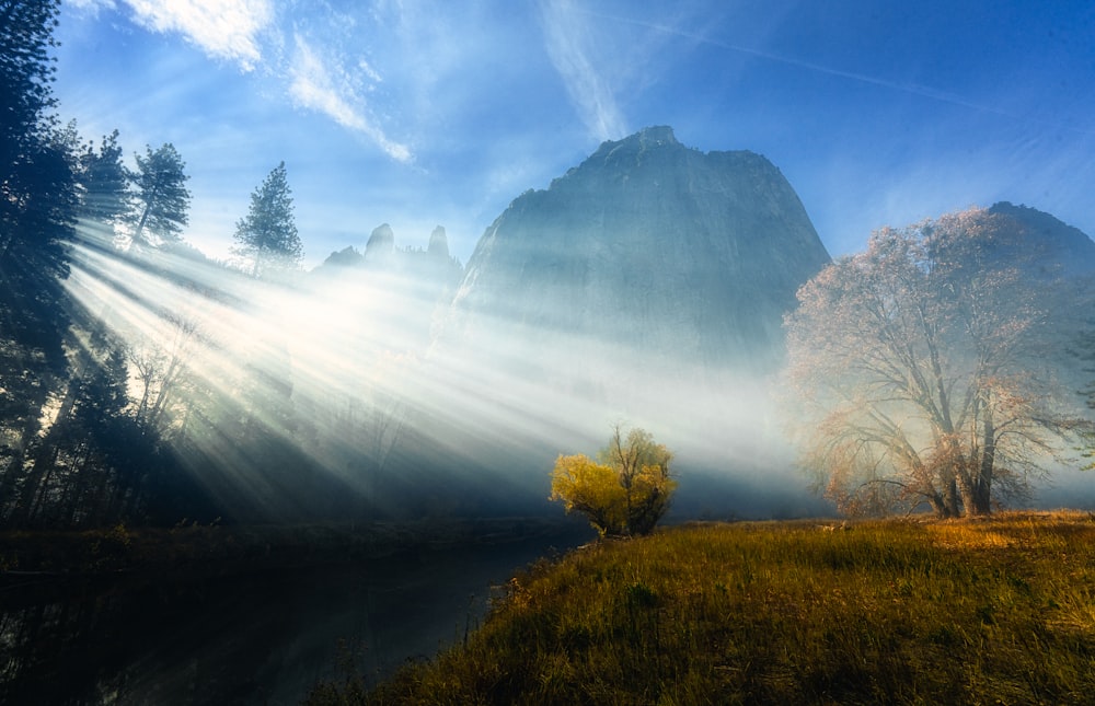 the sun shines brightly through the mist on the mountains