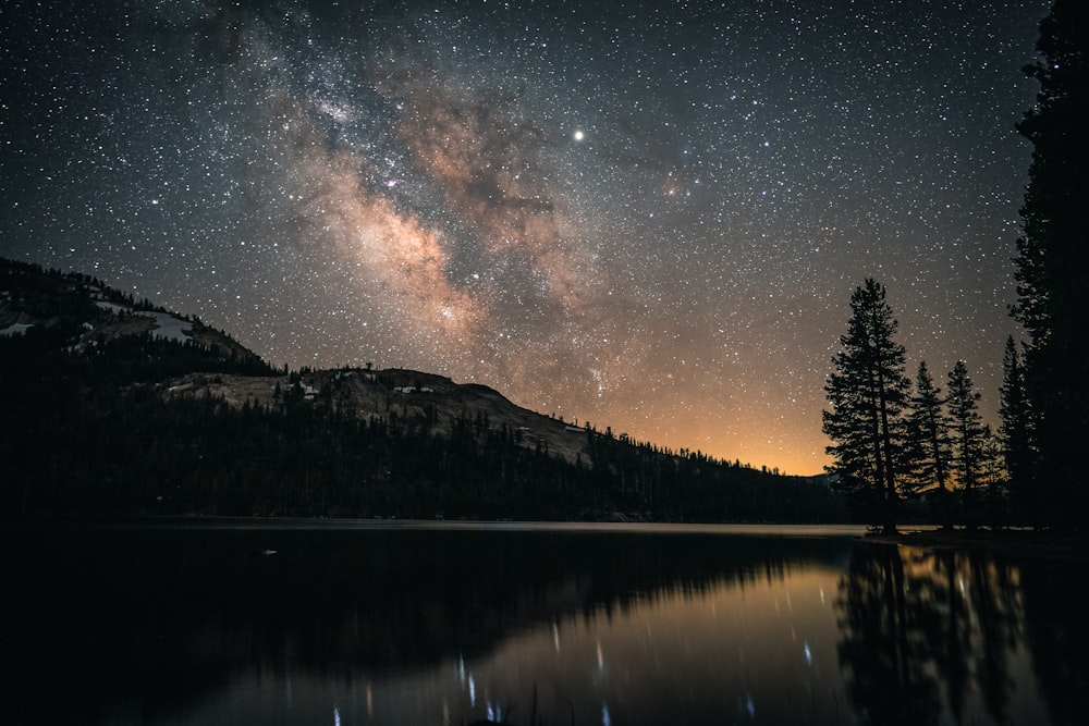 a night sky filled with stars above a lake