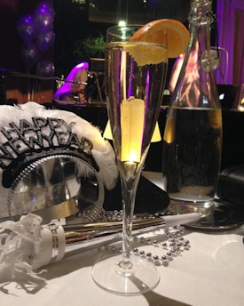 a table topped with a tall glass filled with liquid