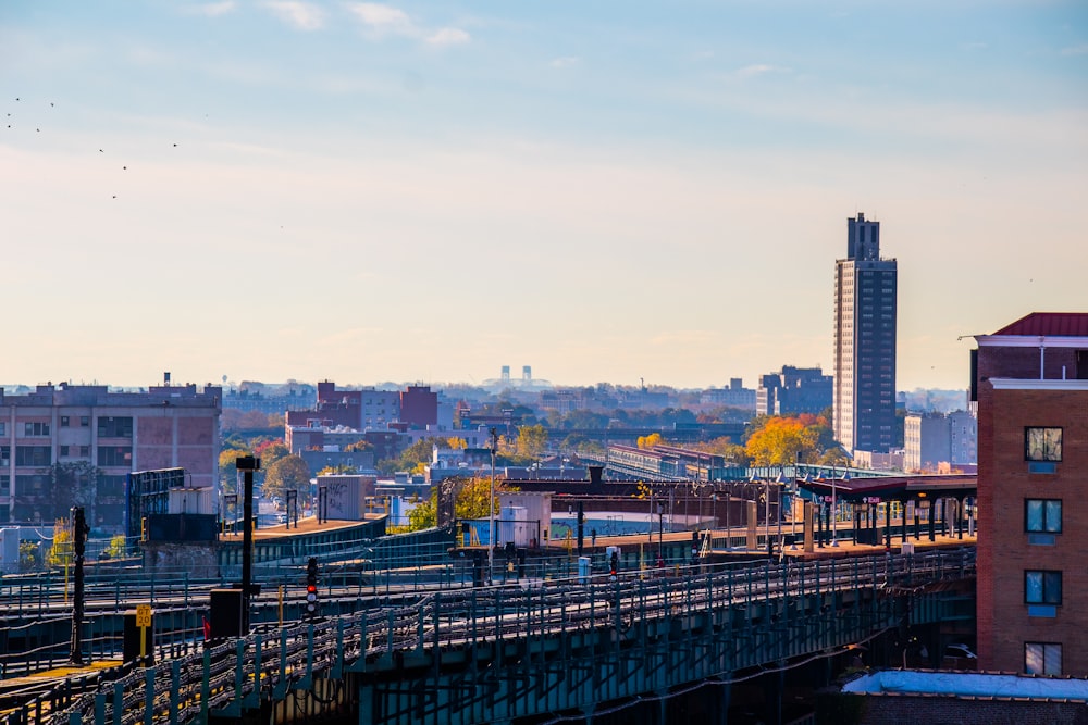 a train traveling over a bridge next to tall buildings