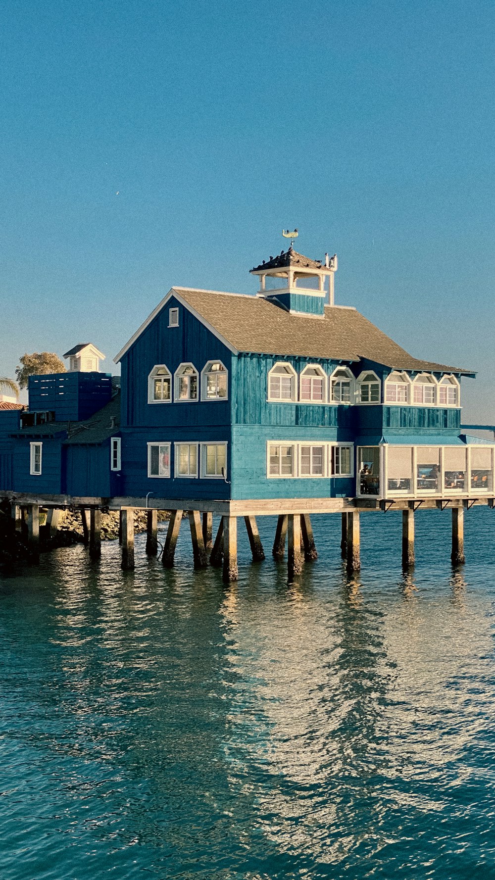 Una casa blu seduta sulla cima di un molo di legno