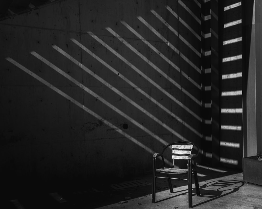 a black and white photo of a chair and a wall
