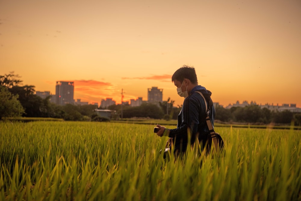 a person standing in a field of tall grass