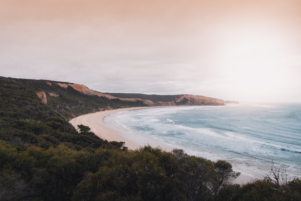 a view of a beach from a hill overlooking the ocean