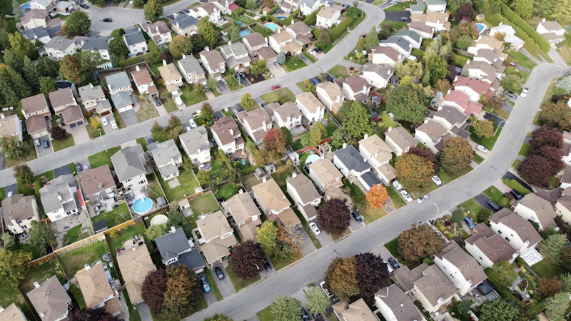 Aerial view of a suburban residential neighborhood with homes and tree-lined streets