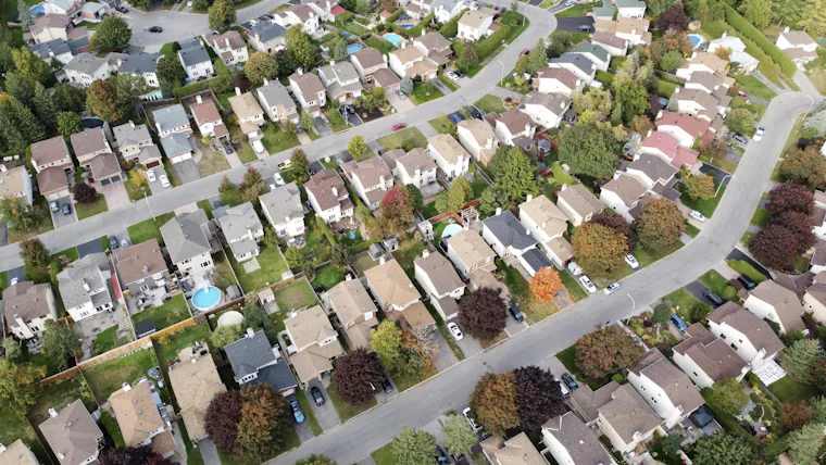 Aerial view of a suburban neighborhood with houses, roads, and trees