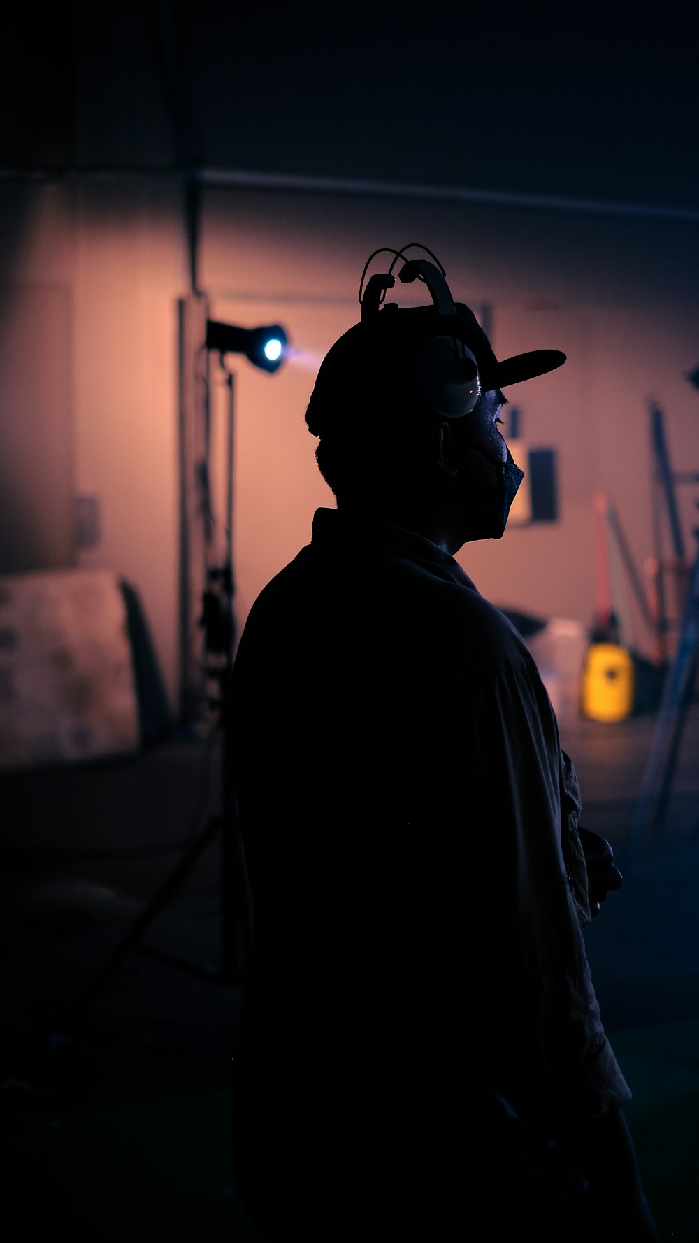 a man wearing a hat and glasses in a dark room