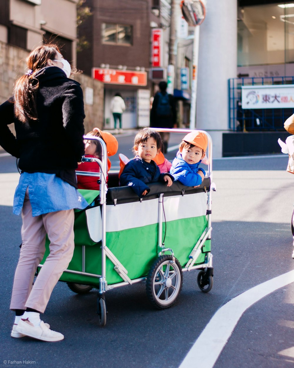 a woman pushing a cart with children in it