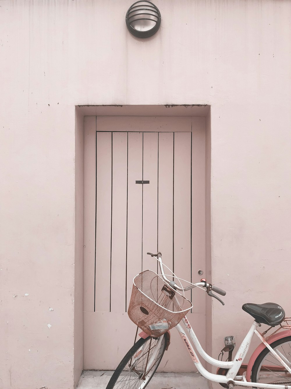 a bicycle parked in front of a pink door