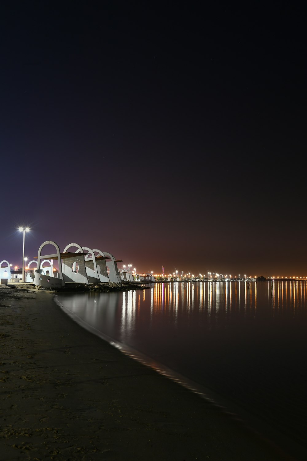 a body of water with a bridge in the background