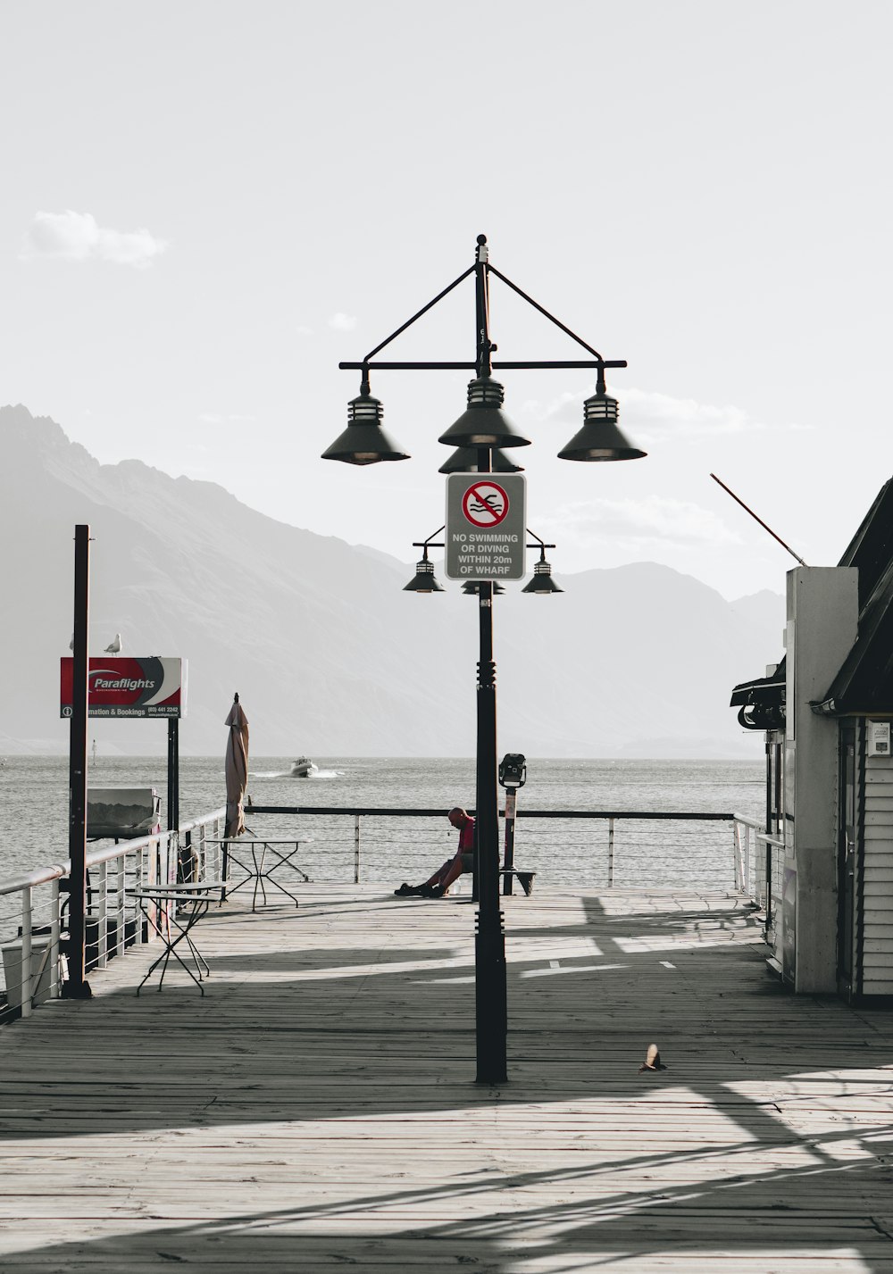 a light pole sitting on top of a pier next to a body of water