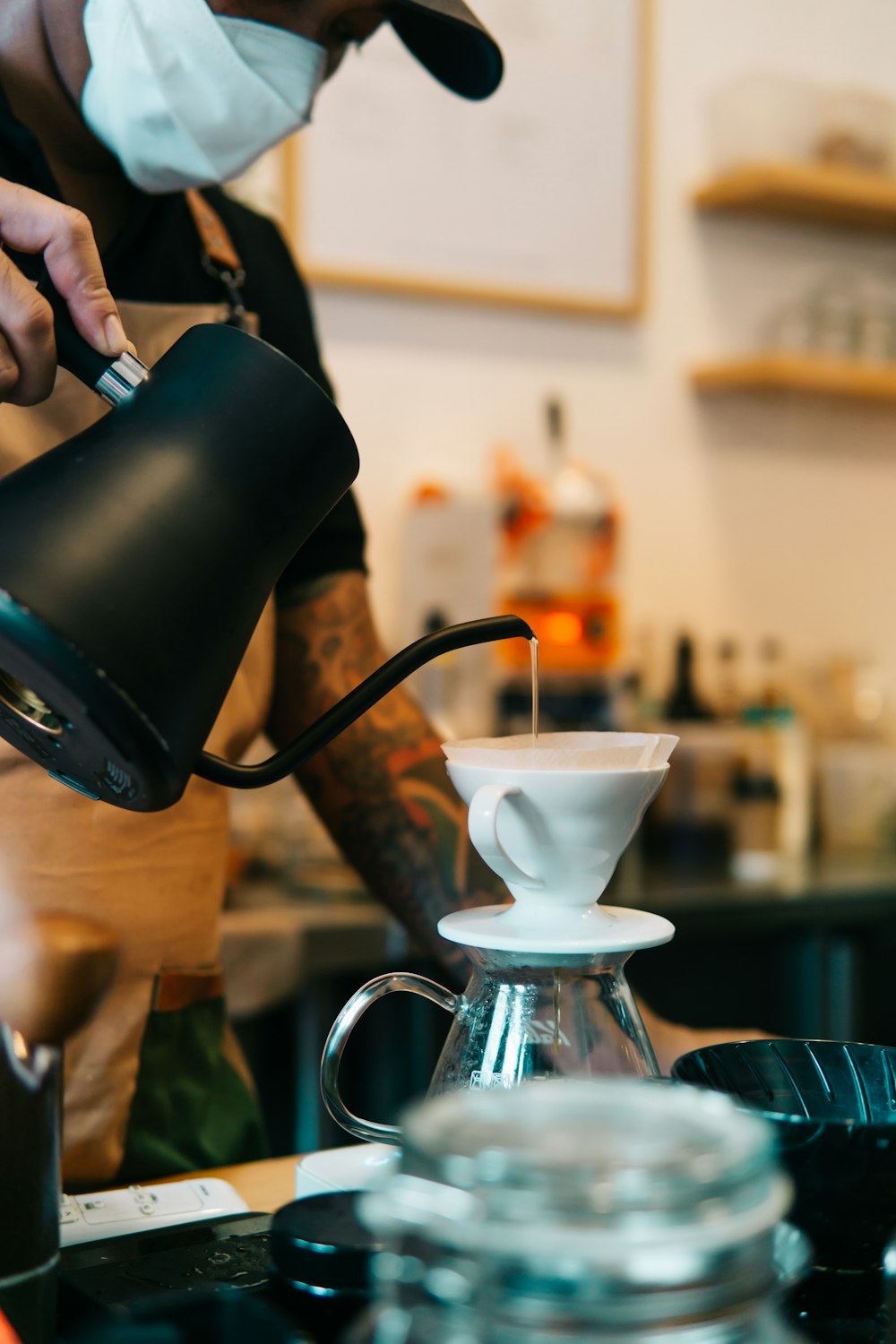 a man in a mask pours a cup of coffee