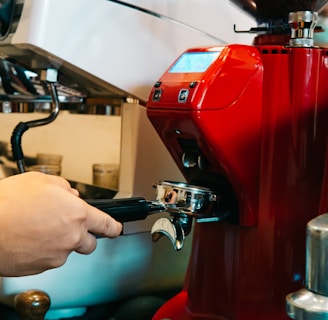 a red coffee machine being filled with liquid