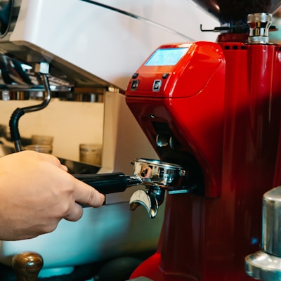 a red coffee machine being filled with liquid