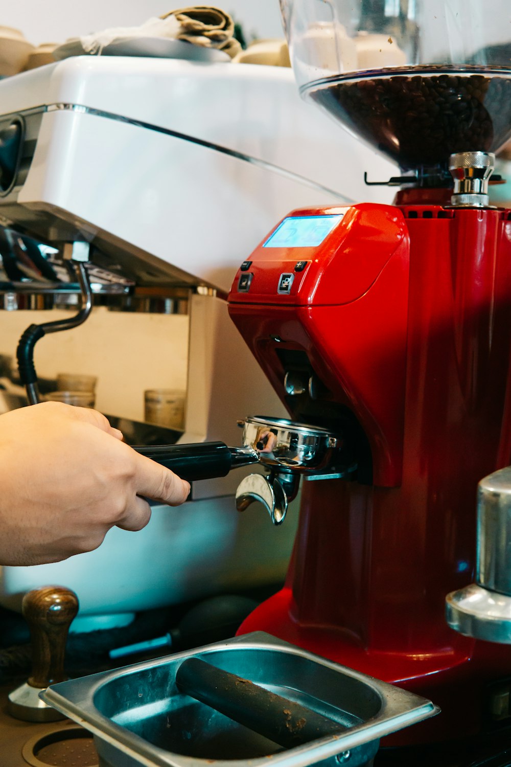 uma máquina de café vermelha sendo preenchida com líquido