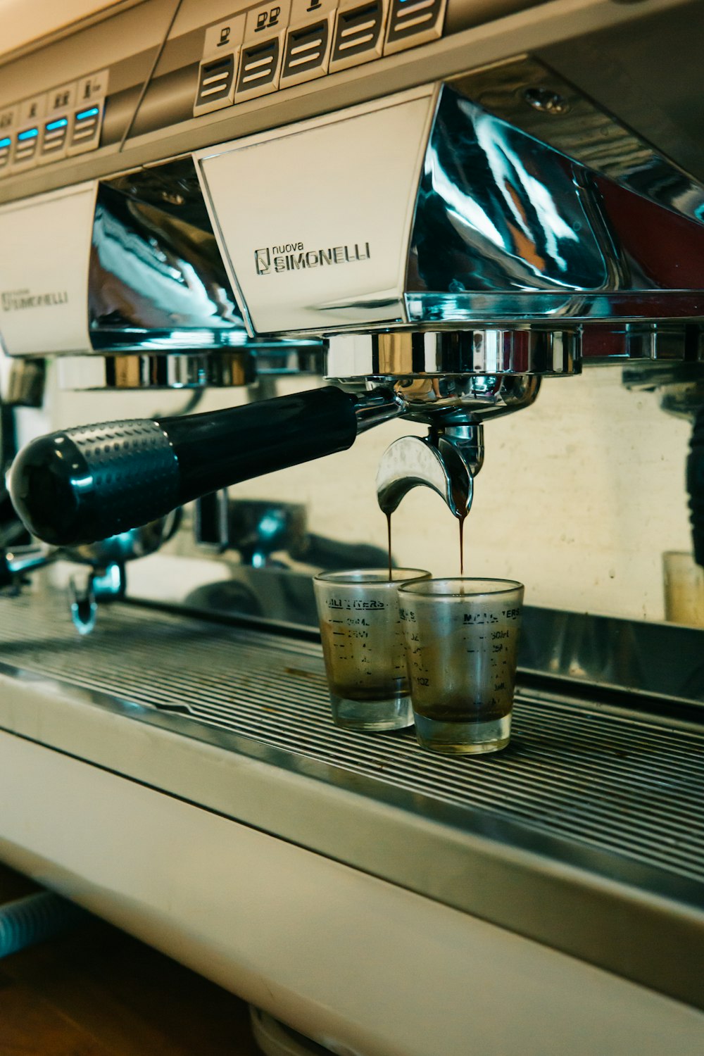 a cup of coffee being poured into a coffee machine