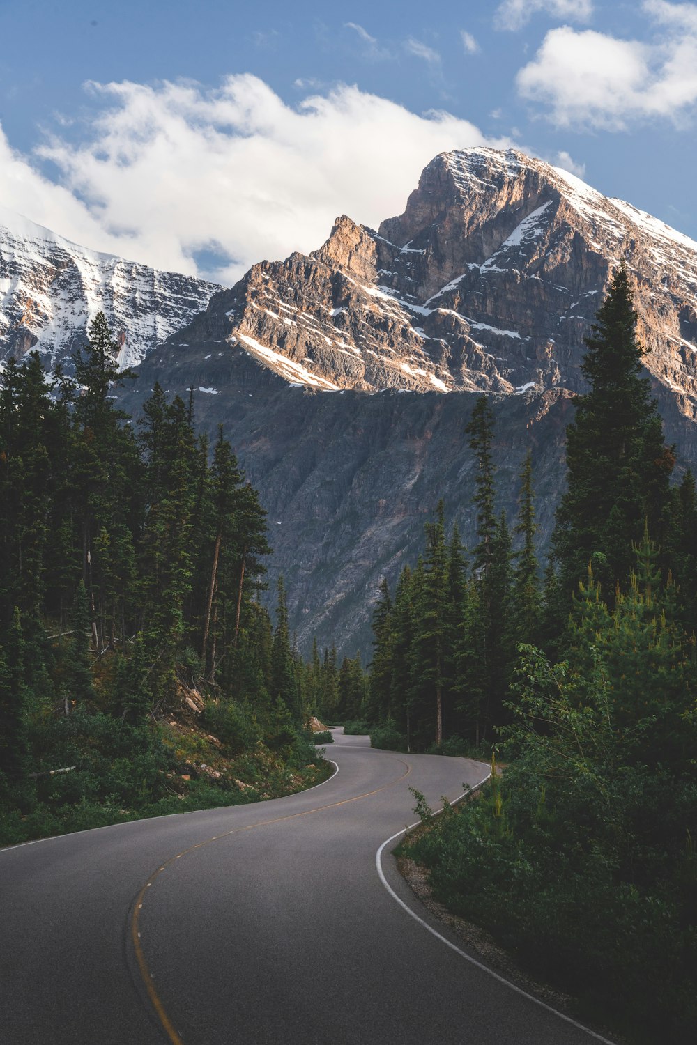 a winding road with a mountain in the background