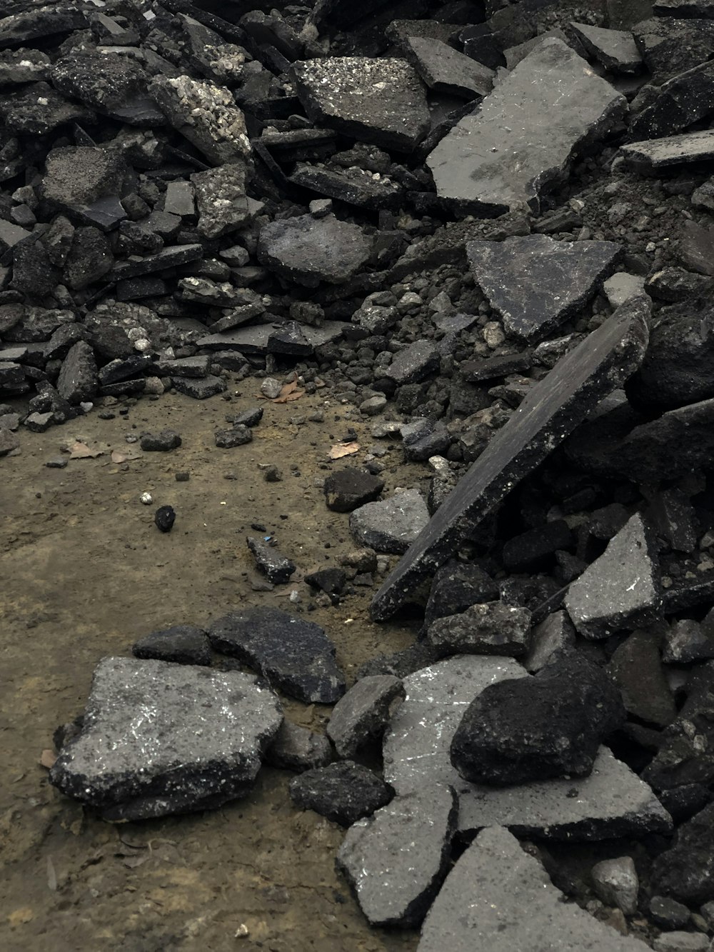 a large pile of rocks and rubble on a dirt ground