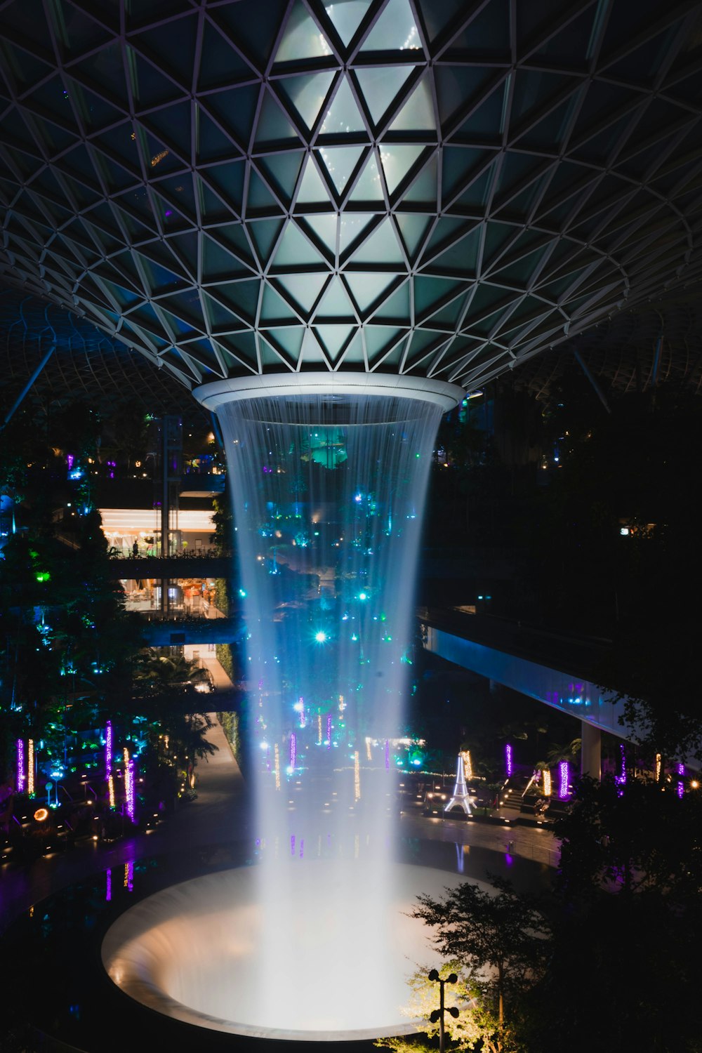 a large fountain is lit up at night