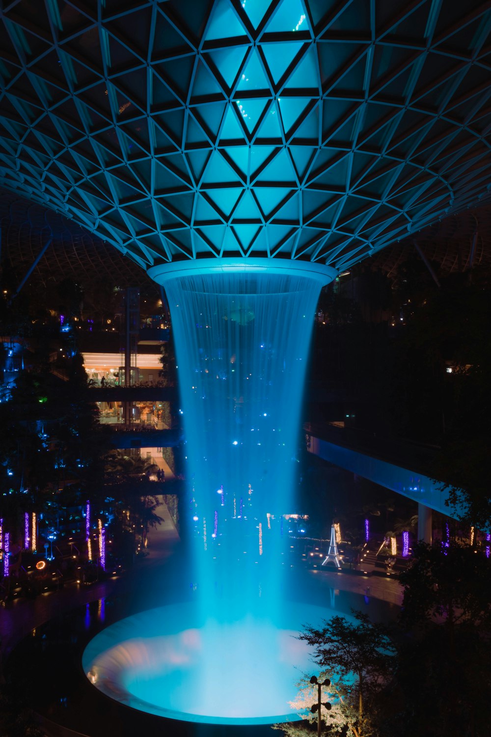a fountain lit up at night in a city