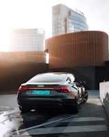 Glossy black Audi with reflections of nearby buildings on its surface.