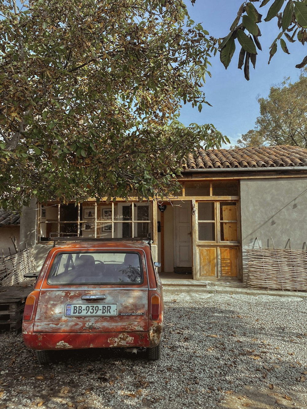 an old car parked in front of a house under construction
