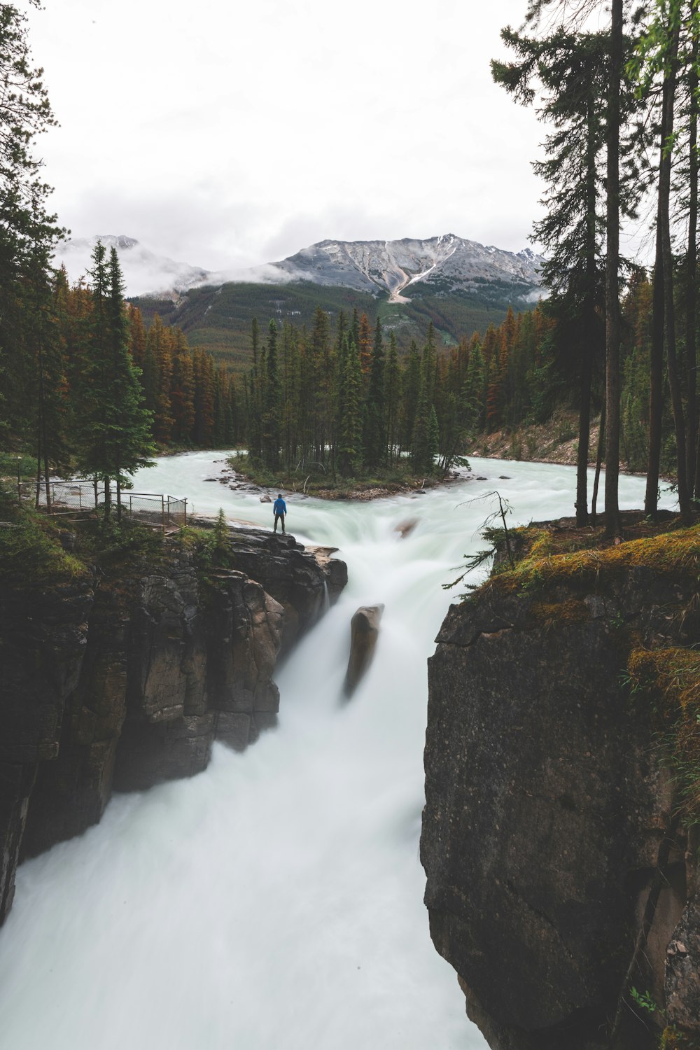 a man standing on the edge of a waterfall