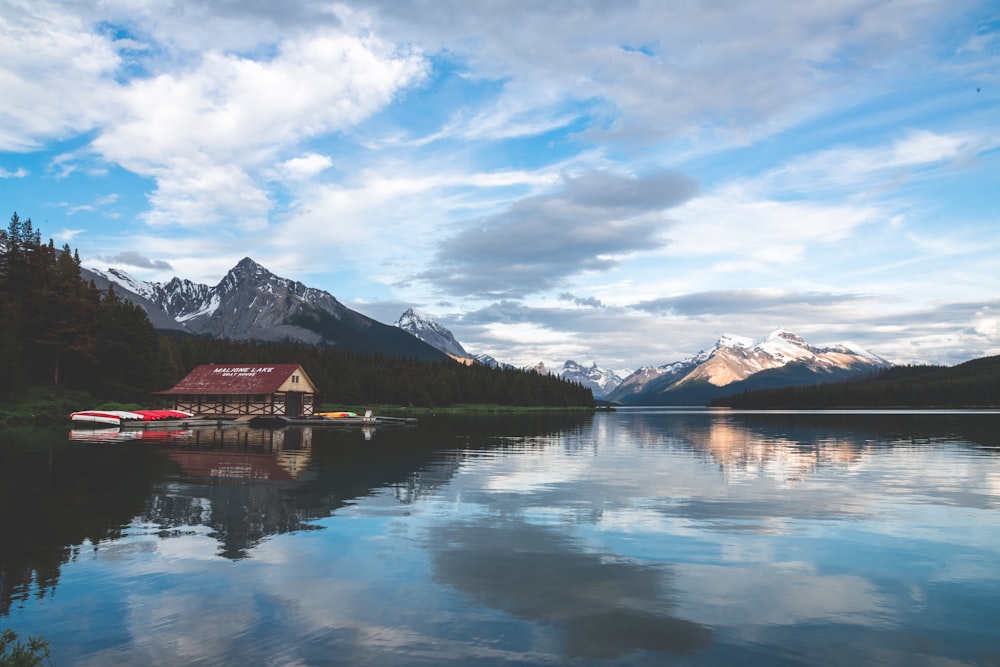Una casa su un lago con le montagne sullo sfondo
