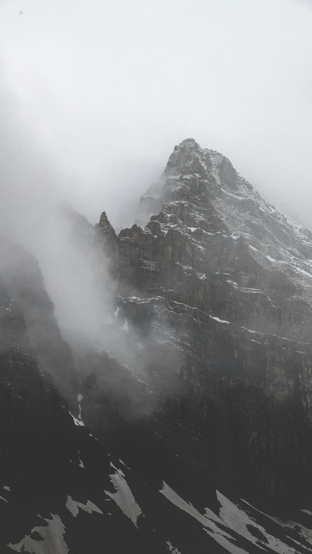 a very tall mountain covered in snow and clouds