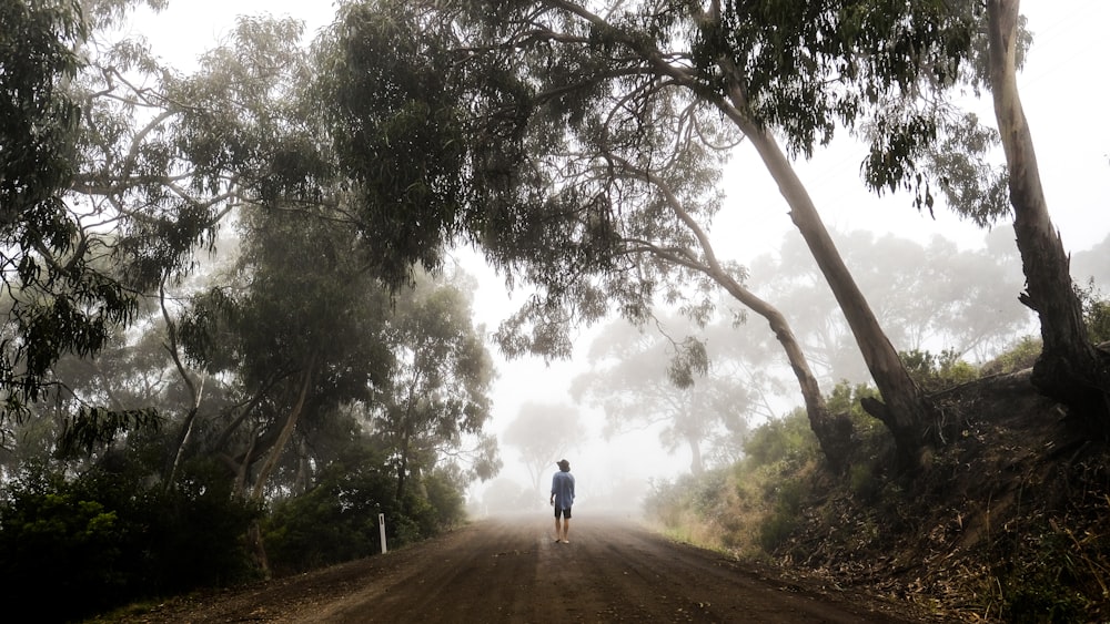 a person is walking down a dirt road