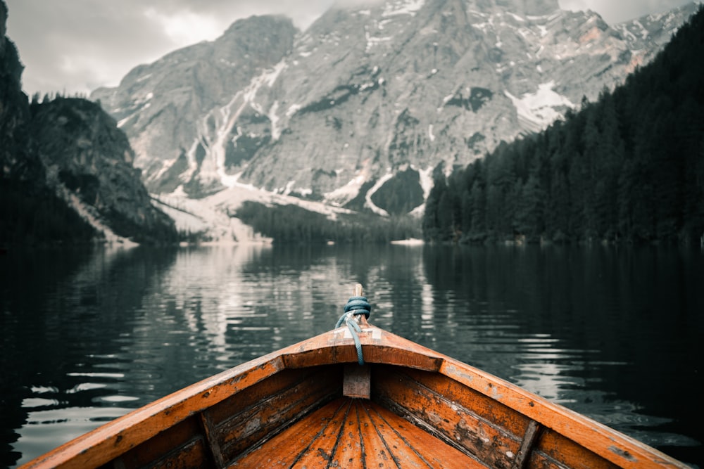 the bow of a boat on a lake with mountains in the background