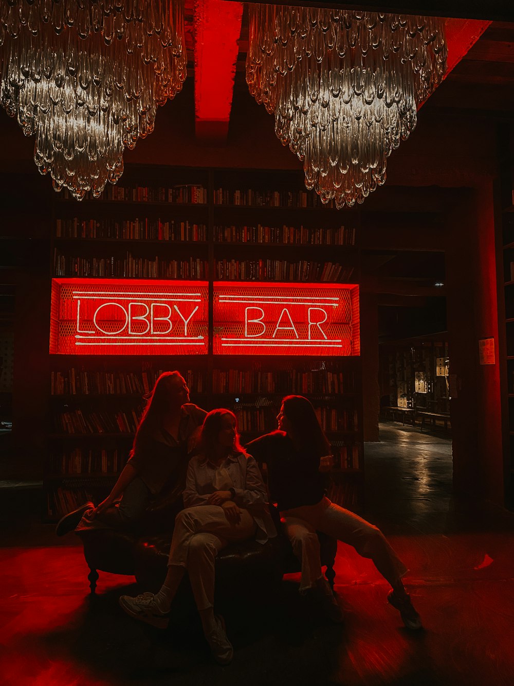 a group of women sitting on a couch in front of a bar