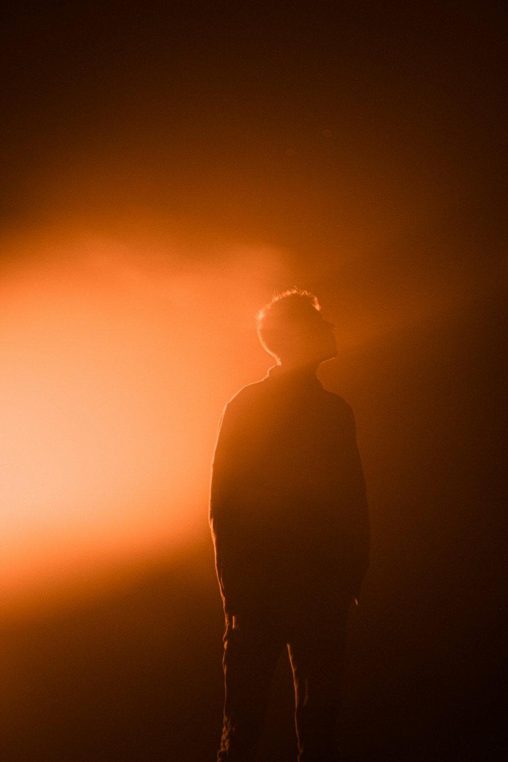 a man standing in the dark with his back to the camera