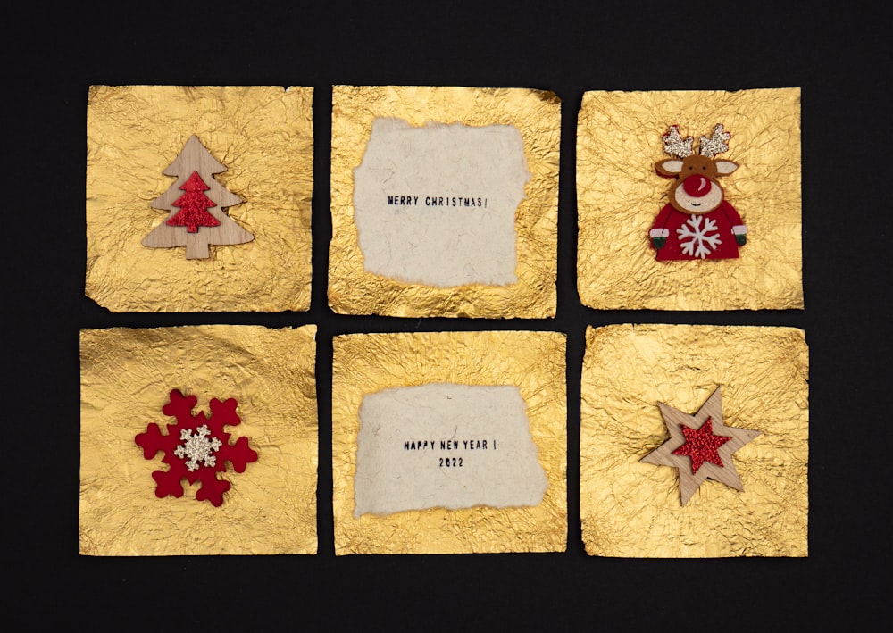 Quattro pezzi di carta dorata con decorazioni natalizie su di essi