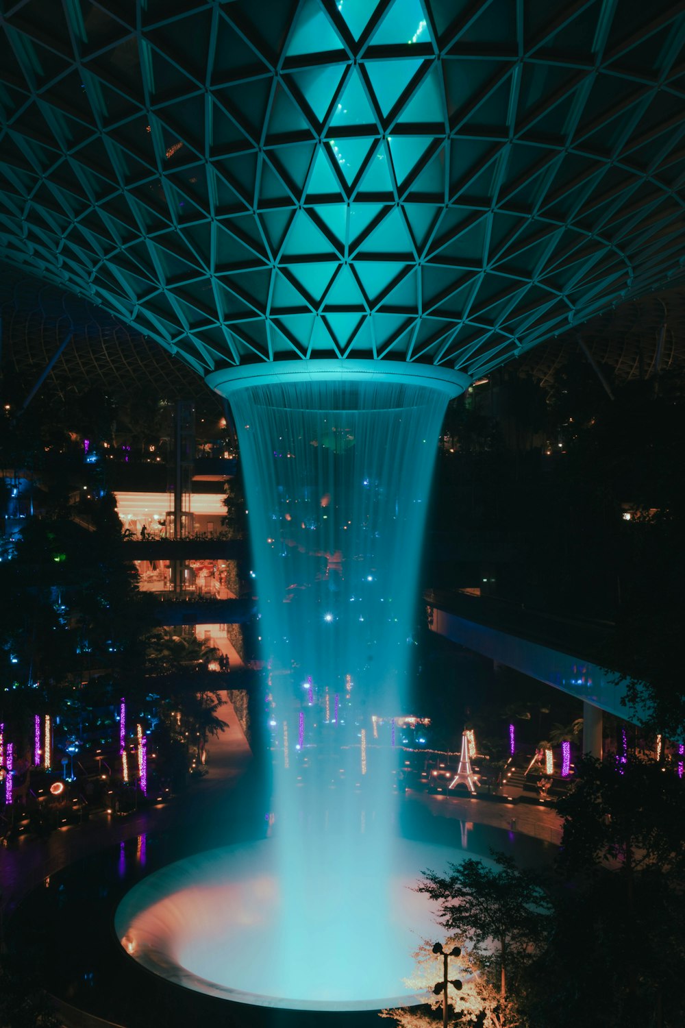 a large fountain is lit up at night