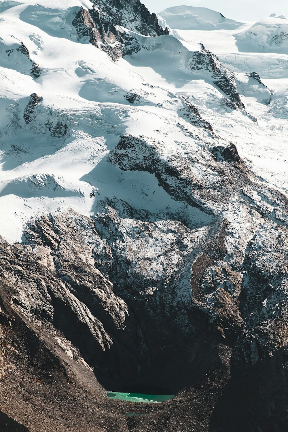 a snow covered mountain with a lake in the middle of it