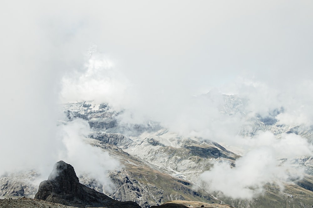 a mountain range covered in snow and clouds