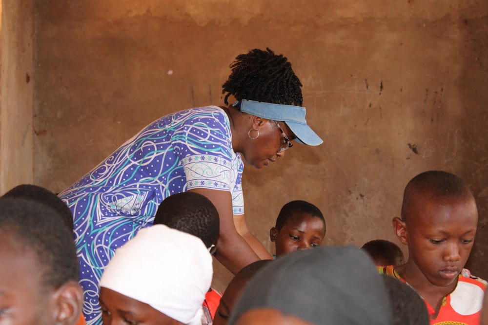 a woman standing in front of a group of children