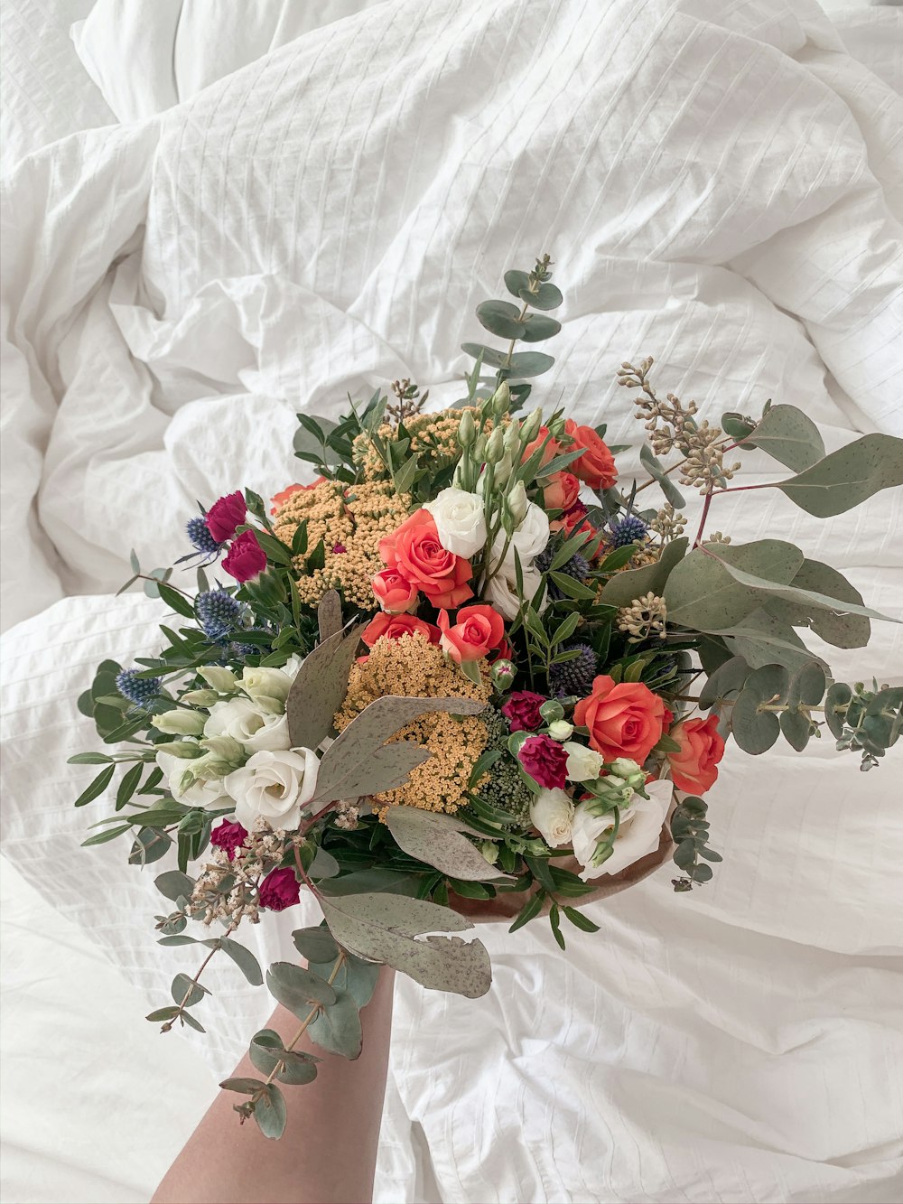 a woman's hand holding a bouquet of flowers