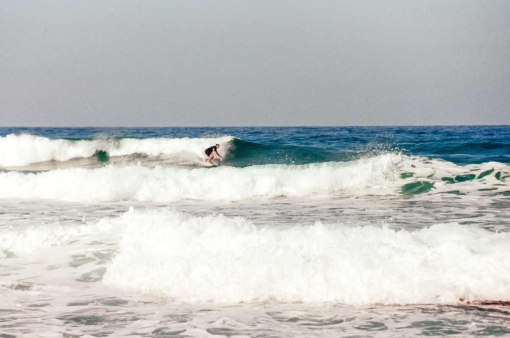 a person riding a wave on top of a surfboard