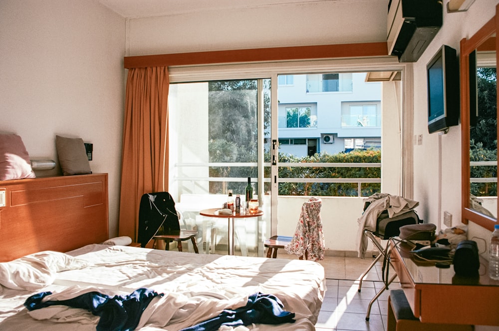 a bed room with a neatly made bed and a large window