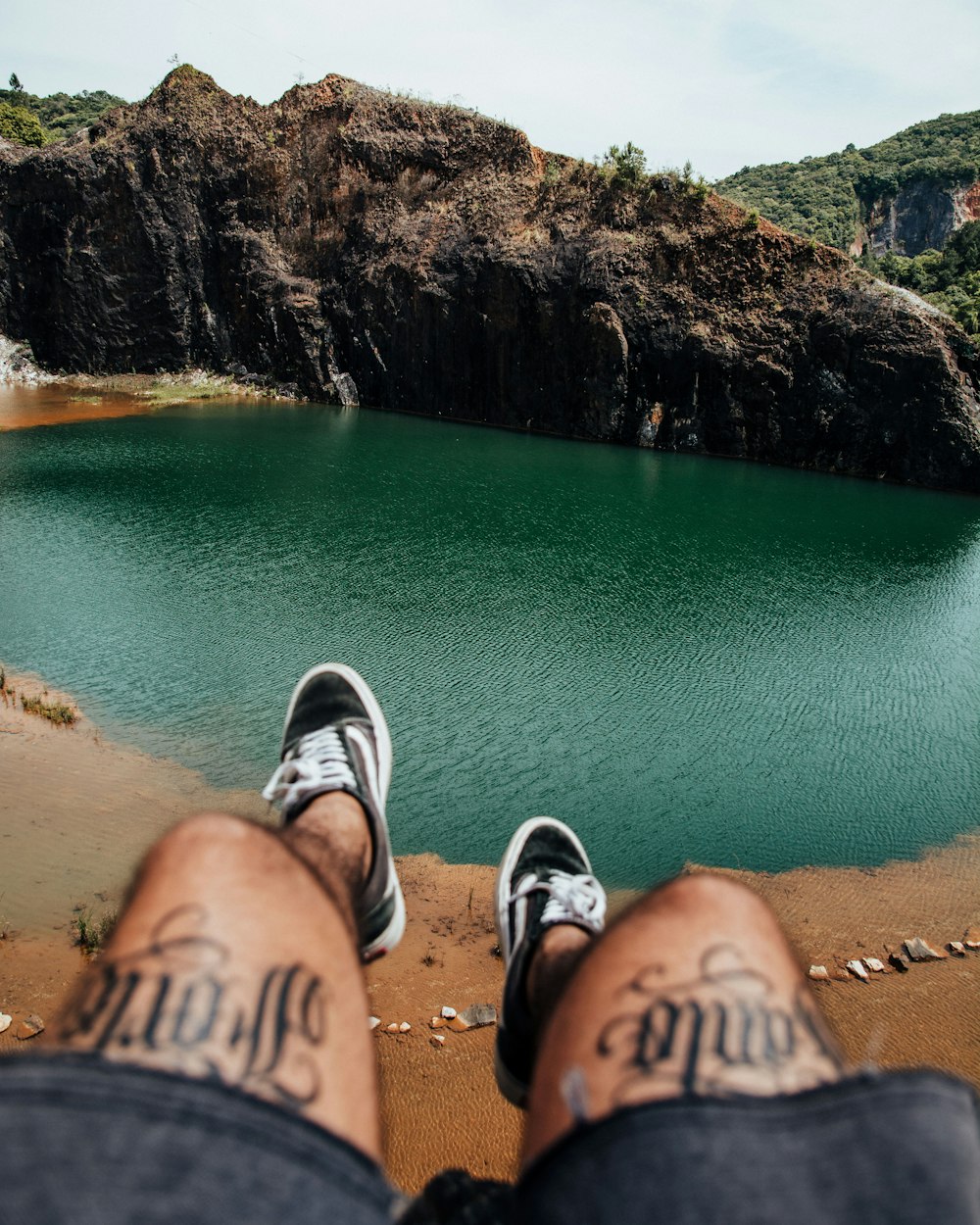 a person with their feet up in front of a lake