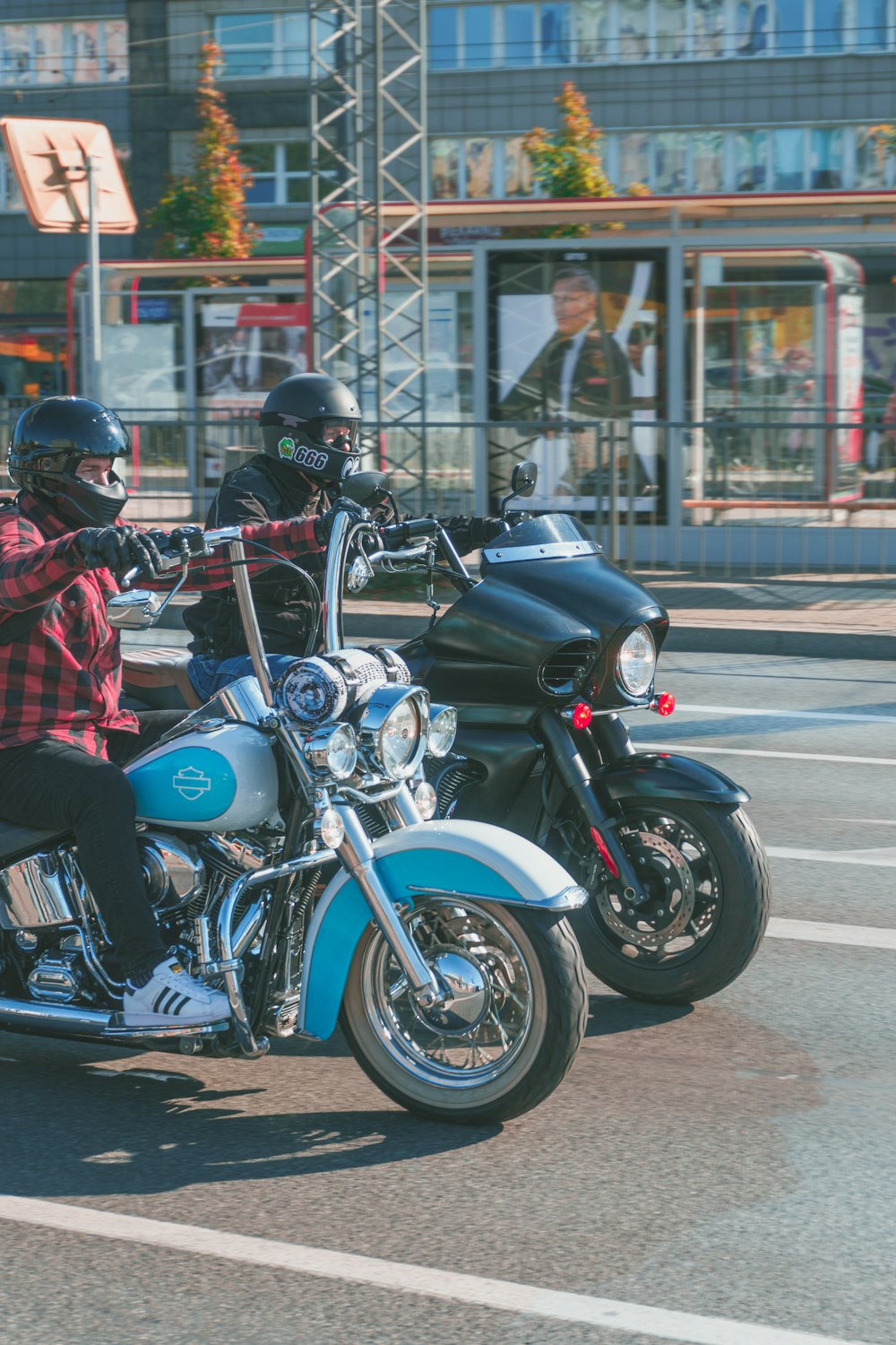 two people riding motorcycles on a city street