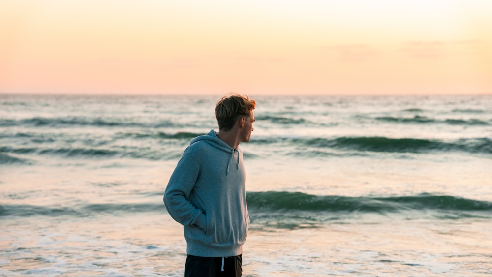 a man standing on a beach next to the ocean