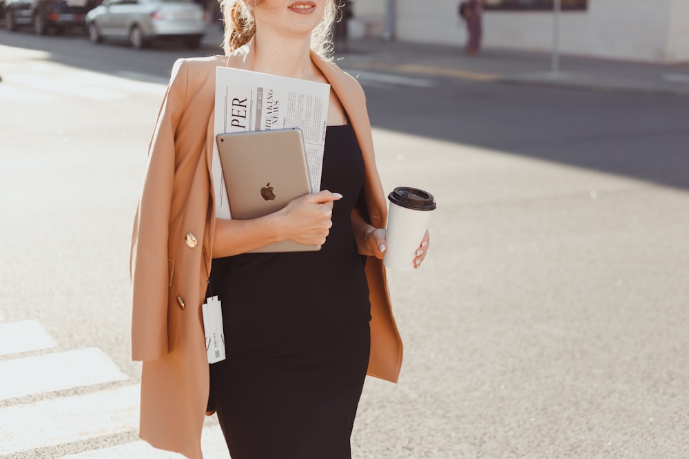 a woman in a black dress holding a cup of coffee