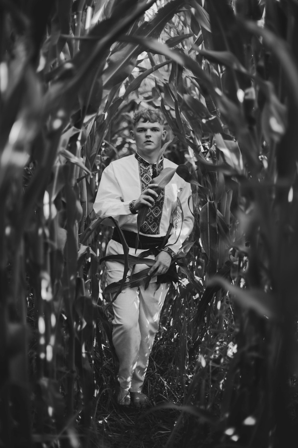 a man in a tie walking through a forest