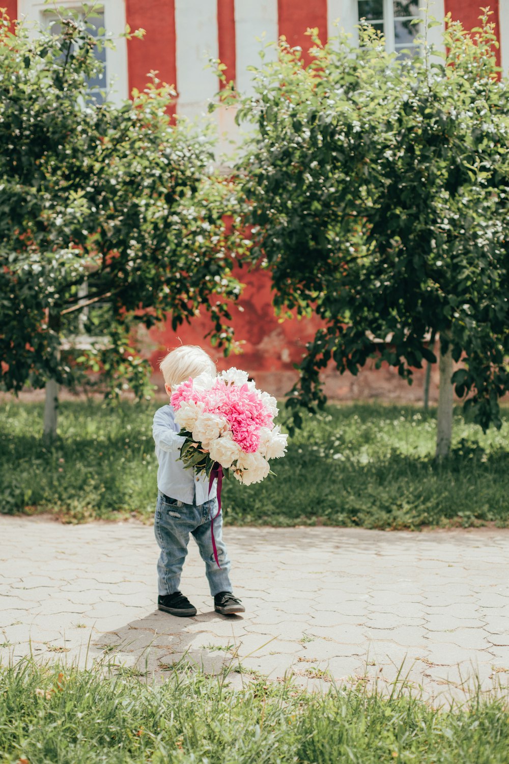 a little boy holding a bouquet of flowers